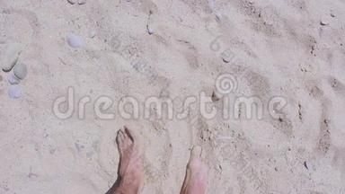 雄脚沿着沙滩行走.. 一个男人喜欢在沙滩上放松。 一个人走在海边的沙滩上。