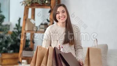 美丽的笑女包装圣诞礼物摆在节日装饰舒适的家的肖像