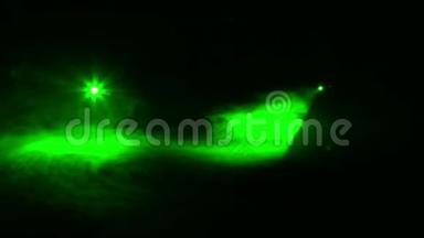 在烟雾毯的黑暗中，轮廓聚光灯发出的绿色光线