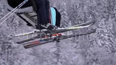 滑雪者乘坐滑雪电梯。 带滑雪板和滑雪靴的腿在森林的雪松的背面。