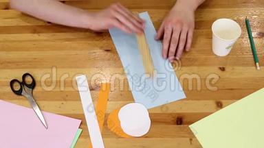 在<strong>美术课</strong>上，老师和孩子用铅笔在纸上画画。 手放在桌面上。 儿童`讲习班