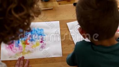 在美术课上，老师和孩子用铅笔在纸上画画。 手<strong>放在桌面上</strong>。 儿童`讲习班