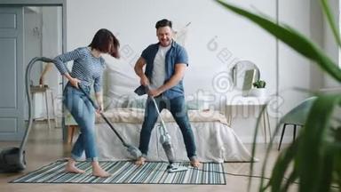 男人和女人在家里玩，在卧室里吸尘地毯跳舞唱歌