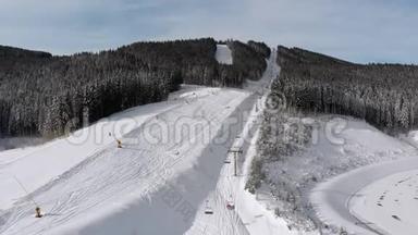 滑雪者在滑雪胜地滑雪升降机附近的高空俯瞰滑雪斜坡。 Bukvel