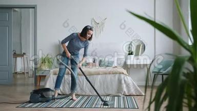 年轻的家庭主妇在卧室用吸尘器打<strong>扫地</strong>板，独自工作