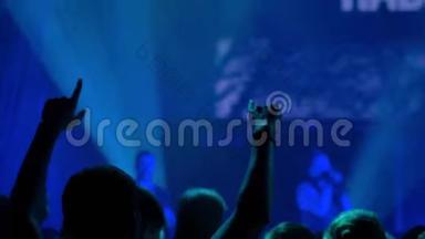 慢动作：舞台前的摇滚音乐会上人们挥舞双手的剪影