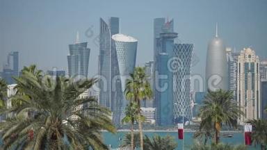 通过模糊的棕榈树俯瞰多哈现代天际线的全景。 <strong>卡塔尔</strong>晴天