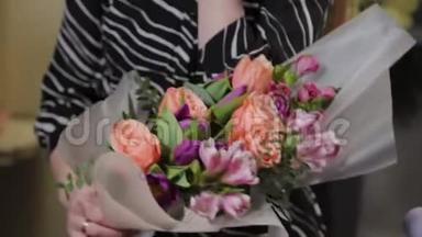 专业的花店正在包装一束花。 为国际妇女节准备`美丽的花束..