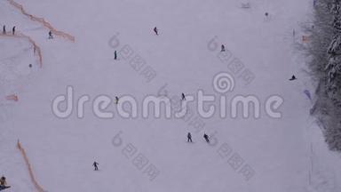 在阳光明媚的日子里，滑雪者和滑雪者在滑雪场的<strong>雪坡</strong>上骑行