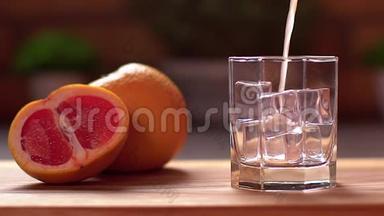 新鲜葡萄柚汁倒入透明玻璃加冰。 把葡萄水果切成薄片放在桌子上。 健康生活方式