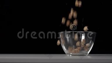 香甜蓬松的焦糖爆米花倒入白色桌子上透明的班级碗中..
