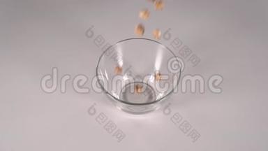 香甜蓬松的焦糖爆米花倒入白色桌子上透明的班级碗中..