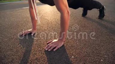 4k平板运动视频，年轻健身者早晨在户外道路上做俯卧撑，夕阳强烈