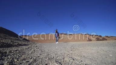 希普斯特女人走过镜头穿过火山，沙漠自然，干旱的气候。 静态<strong>射击</strong>，广角<strong>射击</strong>