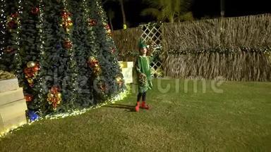 快乐可爱的女孩穿着精灵服装跳舞，在圣诞树附近唱<strong>歌</strong>。 圣诞老人`助手庆祝圣诞<strong>节</strong>，为圣诞<strong>节</strong>感到高兴