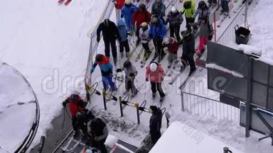 滑雪电梯上的队列。 旋转门的滑雪者队伍和人群