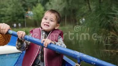 可爱的孩子看着相机微笑。 可爱的孩子拿着桨和微笑。 迷人的小男孩对着镜头微笑。 开心果
