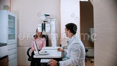 <strong>眼科</strong>治疗-年轻的微笑妇女与医生一起用验光设备检查视力