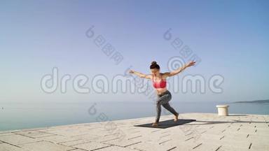 <strong>运动健身</strong>女孩在海上码头练习瑜伽