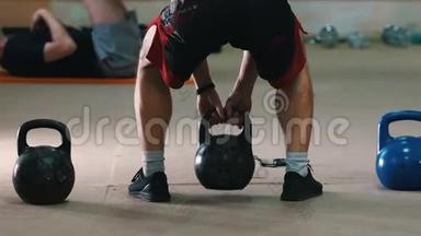 运动训练-一个穿红色短裤的运动员，双手抱着体重蹲着