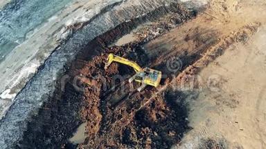 黄色挖掘机在采石场工作时移动污垢。 工业施工现场<strong>重型机械</strong>..