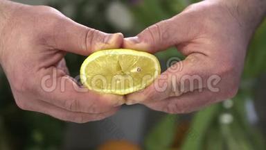 一个男人用双手捏着一片柠檬，整个柑橘汁流在男人的手`靠在他的手上