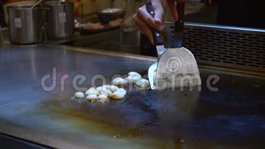 铁板烧厨师在餐厅烹制八爪鱼一个开放的热烤盘