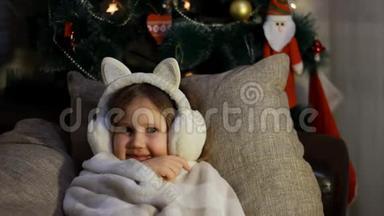 快乐可爱的孩子躺在床底下，微笑着，许愿，等待圣诞老人的礼物。 祝你快乐