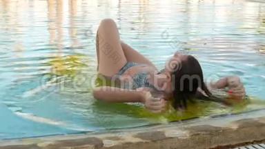 女人在游泳池放松和沐浴阳光