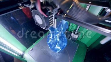 3D打印机在3D打印实验室工作。 一个3D打印机的内部视图，生产一个蓝色花瓶