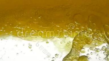 沉淀罐中的金色液体会放出气泡.. 葵花籽油与亚麻籽和气泡结构混合
