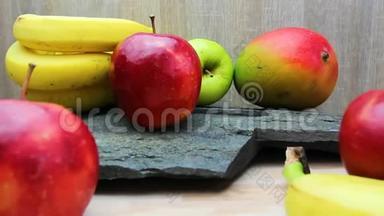 厨房桌子上的新鲜水果和石头纹理。 苹果、芒果和香蕉水果