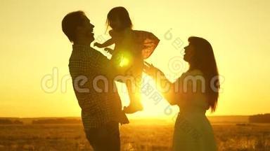 <strong>一家人</strong>带着孩子在夕阳下的田野里。 父亲、<strong>女儿</strong>和母亲正在球场上玩耍。 妈妈和爸爸