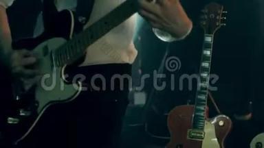 穿着白色衬衫和黑色领带的吉他手弹着电视吉他，震撼舞台