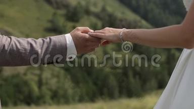 新郎牵着新娘的手，关门。 一对相爱的夫妇在大自然中行走。