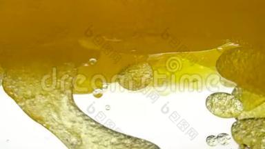 容器中金色液体的特写。 液体黄波线.. 金色的气泡。 为了项目，休息，加油