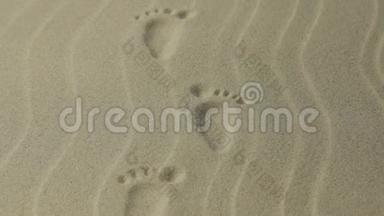 放大。 有花纹的脚印的人，痕迹延伸到远处.. 沙中的脚印..