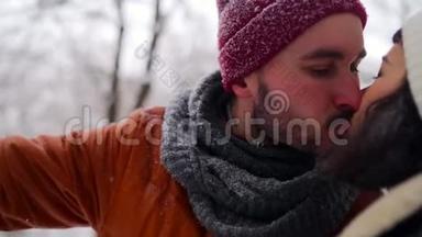 在圣诞节假期的寒假里，在户外享受降雪的嬉皮士男子。 快乐的家伙在雪地里张开双臂