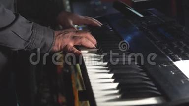 摇滚乐队的钢琴演奏家或键盘演奏家在舞台上站在一个小球或一个俱乐部里演奏合成器