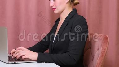 女人坐在办公桌前用笔记本电脑。 年轻的欧洲女商人正坐在办公室里工作