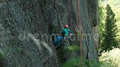 一个年轻的女人用绳子从悬崖上下来。