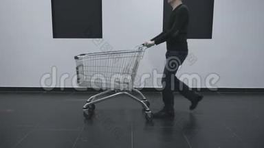 一个人带着一辆空小车来到超市的墙上。 他在商场或超市购物。 黑色星期五
