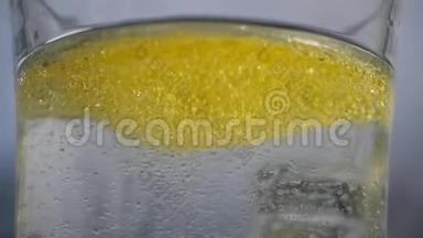 许多黄色的<strong>气泡</strong>和灯泡漂浮在玻璃中，在特写镜头中有清澈的水。 水中的油会变成<strong>气泡</strong>