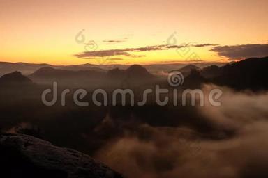 在瑞士萨克森州流行的山谷里，夕阳西下，雾气<strong>飘摇</strong>. 峰峦从雾中伸出