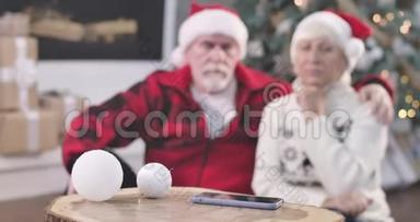 焦点从智能手机<strong>转变</strong>为坐在圣诞树旁边的悲伤的老夫妇的脸。 待召退休人员