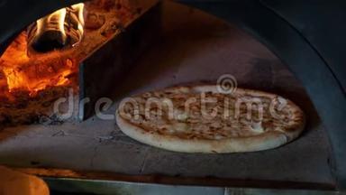 意大利比萨饼和4个奶酪是在烤箱里煮的，餐厅厨师从一个木头烤箱里取出比萨饼。
