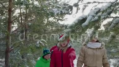 友好的家庭妈妈，爸爸，儿子和女儿在针叶林散步在寒假。 一家人走进来