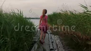 快乐的小女孩在木板上的<strong>芦苇丛</strong>中跑到湖边