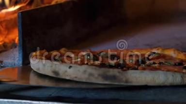意大利披萨和西红柿是在烤箱里煮的，餐厅厨师从木材烤箱里取出披萨。