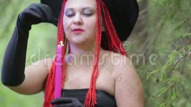 一个红头发，戴着黑<strong>帽子</strong>的年轻女巫在森林里施展<strong>魔法</strong>